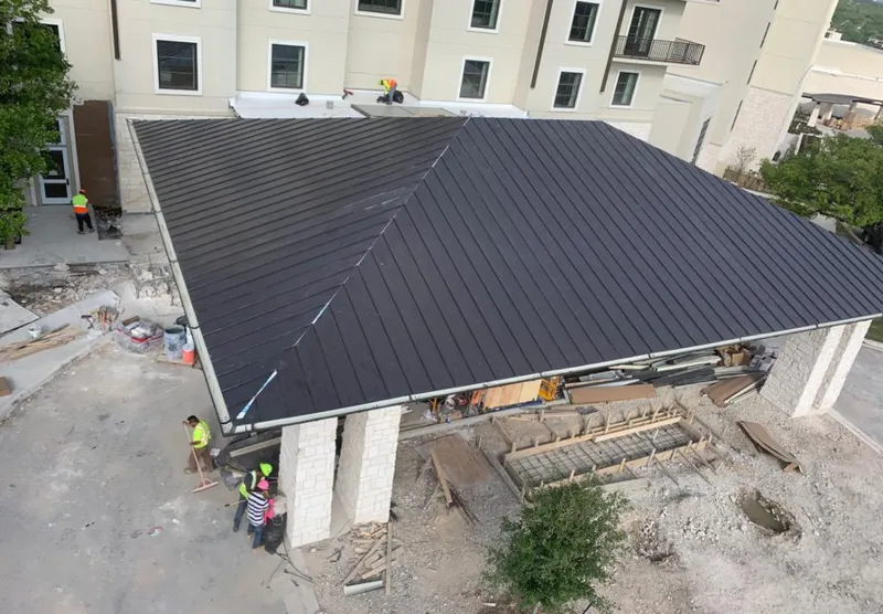Metal roofing installation team working on a commercial building in Normal
